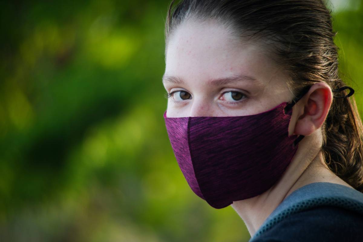 Close-up of quality designer fabric masks showing triple-layer construction and flatlock stitching detail