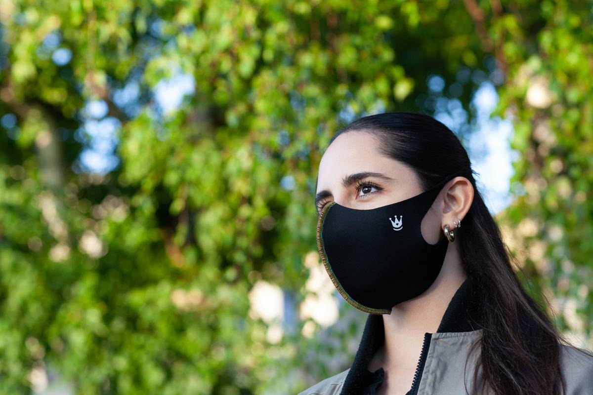 Woman wearing a well-fitted reusable face mask everyday for future protection while walking in a city