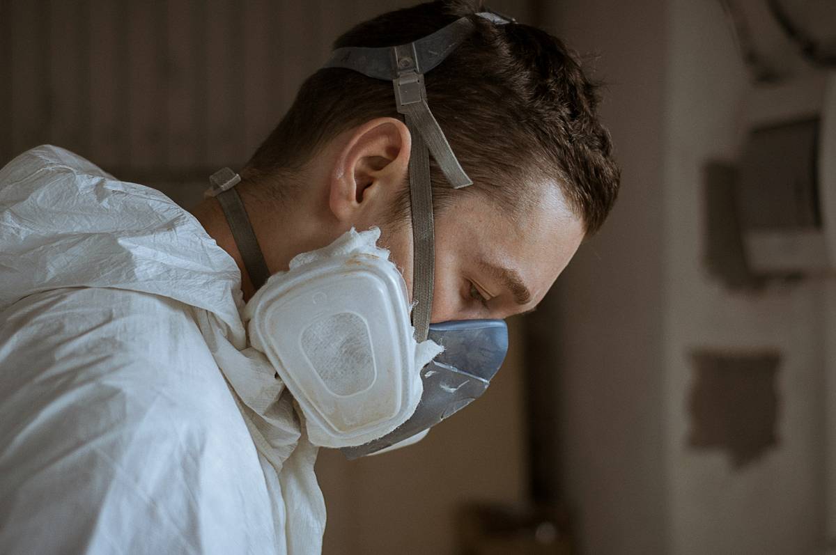 Woman applying serum while wearing moldex reusable dust masks during at-home facial